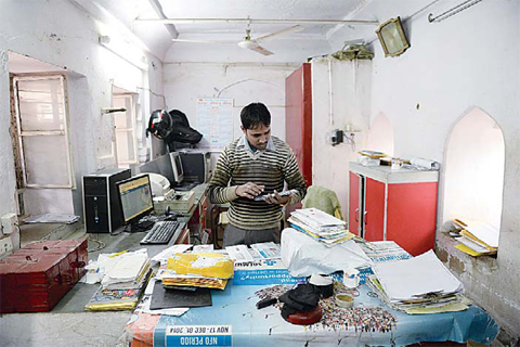 Indian post office employee working inside a post office in a village in the Rajasthan district of Neemrana