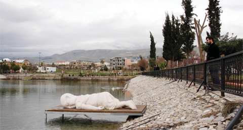 SULAIMANIYAH, Iraq: People look yesterday at a sculpture by artist Bakhtiar Halabjay depicting Aylan Kurdi, a three-year-old Syrian boy who drowned off Turkey, displayed on a pier at Azadi (Freedom) Park in this northern Iraqi Kurdish city. The sculpture replicates the photograph of tiny Aylan’s lifeless body on the beach at Bodrum after he drowned on the crossing to Greece, that rapidly went viral on social media and caused a global outcry as it put a human face to the dangers refugees risk trying to reach safety in Europe. —AFP