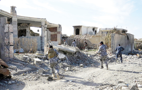 RAMADI: Iraq government troops remove bombs planted in houses and streets in Ramadi’s Husseiba eastern district yesterday, after retaking the city from the Islamic State group. — AFP