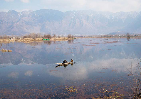 KASHMIR: Kashmiri men row their boat in the waters of Nigeen Lake on the outskirts of Srinagar, Indian controlled Kashmir. Set in the Himalayas at 5,600 feet above sea level, Kashmir is a green, saucer-shaped valley full of fruit orchards and surrounded by snowy mountain ranges. —AP