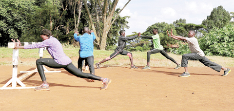 ITEN: Kenyan athletes stretching after their morning workout at the Kamariny stadium at Iten in the Rift Valley, some 329 kms north of Nairobi.