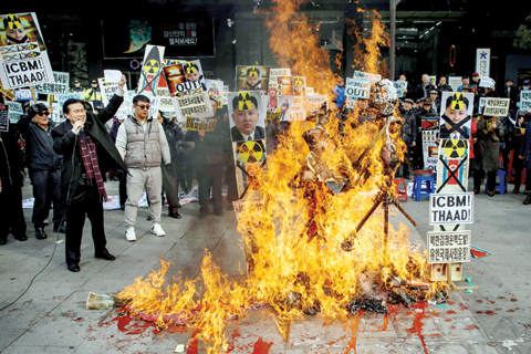 SEOUL: Anti-North Korean activists burn placards showing North Korean leader Kim Jong-Un as they protest the latest nuclear test and rocket launch by Pyongyang. — AFP