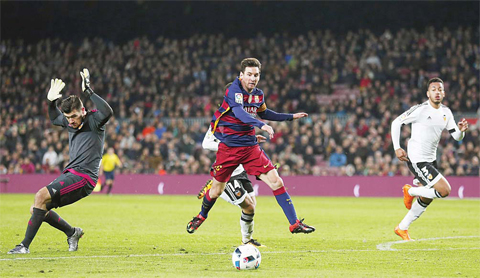 BARCELONA: FC Barcelona’s Lionel Messi, center, duels for the ball against Valencia’s goalkeeper Mathew Ryan, left, during a semifinal, first leg, Copa del Rey soccer match at the Camp Nou stadium. — AP