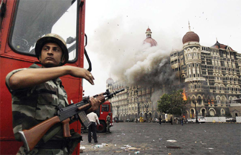 MUMBAI: In this Nov 29, 2008, file photo, an Indian soldier takes cover as the Taj Mahal hotel burns during gun battle between Indian military and militants inside the hotel.—AP