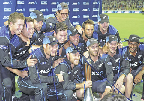 HAMILTON: New Zealand captain Brendon McCullum, bottom center, holding the Hadlee Chappell trophy poses for a photo with his teammates after they won the series over Australia in the 3rd One Day International Cricket match at Seddon Park in Hamilton, New Zealand, yesterday. — AP
