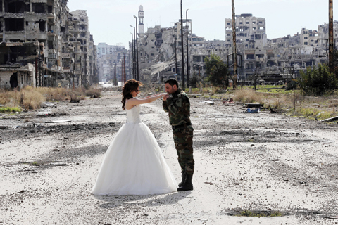 Newly-wed Syrian couple Nada Merhi,18, and Hassan Youssef,27, pose for a wedding picture amid heavily damaged buildings in the war ravaged city of Homs on Friday. A Syrian photographer thought of using the destruction of Homs to take pictures of newly wed couples to show that life is stronger than death.  – AFP 