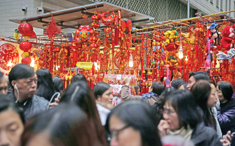 People walking past a stall selling Lunar New Year decorations in a market in the Wan Chai district. — AFP photos