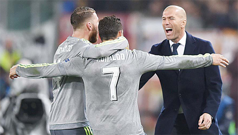 ROME: Real Madrid’s Portuguese forward Cristiano Ronaldo (C) celebrates with Real Madrid’s defender Sergio Ramos and Real Madrid’s French coach Zinedine Zidane after scoring during the UEFA Champions League football match AS Roma vs Real Madrid. —AFP