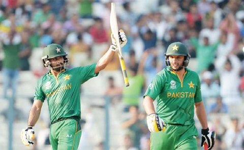 KOLKATA: Pakistan’s Mohammad Hafeez (left) is watched by captain Shahid Afridi as he celebrates after scoring a half-century (50 runs) during the World T20 cricket tournament match between Pakistan and Bangladesh yesterday.— AFP