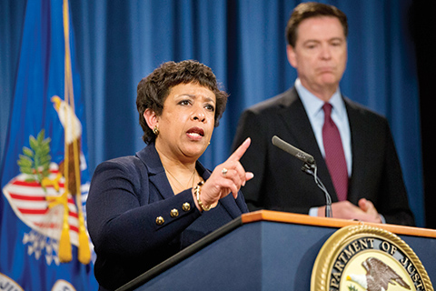 Attorney General Loretta Lynch, accompanied by FBI Director James Comey, speaks during a news conference at the Justice Department in Washington, Thursday, March 24, 2016. Seven hackers tied to the Iranian government were charged Thursday in a series of punishing cyberattacks on a small dam outside New York City and on dozens of banks _ intrusions that reached into American infrastructure and disrupted the financial system, U.S. law enforcement officials said. (AP Photo/Jacquelyn Martin)