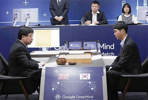 SEOUL: South Korean professional Go player Lee Sedol, right, prepares for his second stone against Google’s artificial intelligence program, AlphaGo, as Google DeepMind’s lead programmer Aja Huang, left, sits during the Google DeepMind Challenge Match in Seoul, South Korea, yesterday. Google’s computer program AlphaGo defeated its human opponent, South Korean Go champion Lee Sedol, yesterday in the first game of a historic five-game match between human and computer. —AP