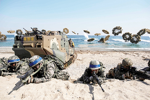 TOPSHOT - South Korean and US soldiers take a position during an annual joint military landing exercise in Pohang, on South Korea's southeast coast, on March 12, 2016. Participation in the joint exercises -- known as Key Resolve and Foal Eagle -- has been bumped up this year to involve 300,000 South Korean and around 17,000 US troops, as well as strategic US naval vessels and air force assets. Pyongyang has long condemned the drills, which stretch over nearly two months, as provocative rehearsals for invasion, while Seoul and Washington insist they are purely defensive in nature. / AFP / Ed Jones