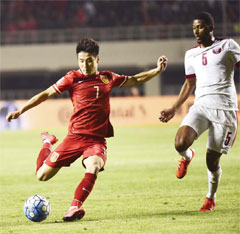 China’s Wu Lei, left, fights for the ball against Qatar’s Abdulaziz Hatem