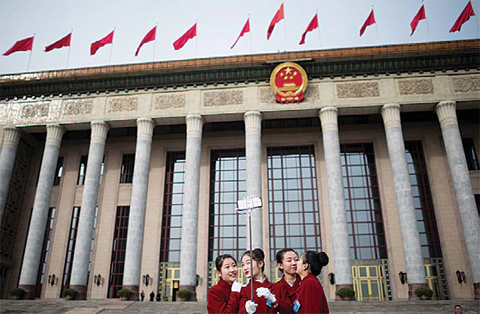 BEIJING: Hostesses pose for selfies outside the Great Hall of the People in Beijing during the second day of the National People’s Congress yesterday. —AFP