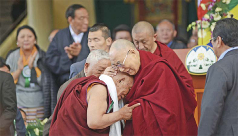MCLEOD GANJ: His Holiness the Dalai Lama (R) greets his former physician Dr Yeshi Dhonden during the Centenary celebration of the Men-Tsee-Khang (Tibetan Medical Institute) on March 23, 2016. — AFP