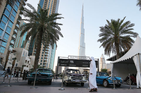 DUBAI: An Emirati looks at classic cars displayed in downtown Dubai. Dubai, whose airport is the world’s busiest for international passengers, announced yesterday it will introduce a tax on travelers to help finance expansion, as Gulf governments grapple with plummeting revenues. — AFP