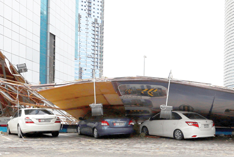 A construction zone barrier is seen on parked cars after it fell following a heavy rainstorm yesterday in Abu Dhabi.
