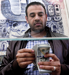 CAIRO: A man counts US dollars at an exchange office in Cairo yesterday