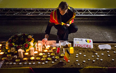 A man lights a candle during a tribute to the victims of the Brussels terror attacks, in Trafalgar Square in central London on March 24, 2016.nGrieving Belgians observed a minute of silence on the third and final day of mourning for the 31 people killed in the March 22 attacks on the airport and a metro station, in the symbolic heart of Europe, putting security agencies across the continent on edge. / AFP PHOTO / JUSTIN TALLIS