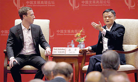 Facebook CEO Mark Zuckerberg, left, listens as Jack Ma, executive chairman of the Alibaba Group, speaks during a panel discussion held as part of the China Development Forum at the Diaoyutai State Guesthouse in Beijing, yesterday. —AP