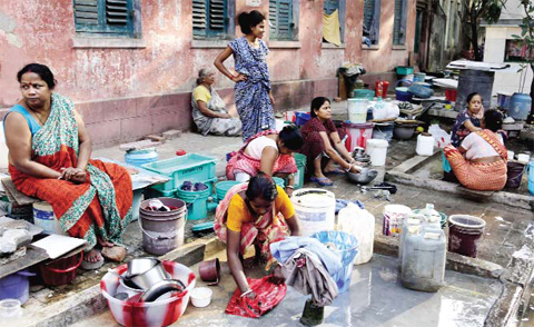 KOLKATA, India: Residents of an area gather around a roadside water source to wash their clothes and fill drinking water for their houses in Kolkata. — AP