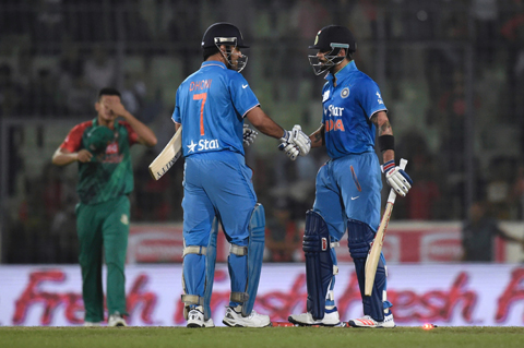 DHAKA: Indian cricketer Virat Kohli (R) shakes hand with captain Mahendra Singh Dhoni (C) after winning the match during the Asia Cup T20 cricket tournament final match between Bangladesh and India at the Sher-e-Bangla National Cricket Stadium in Dhaka yesterday. – AFP