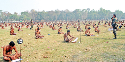 MUZAFFARPUR, India: Indian army candidates sit in their underwear in a field as they take a written exam after being asked to remove their clothing to deter cheating during a recruitment day on Feb 28, 2016. — AFP