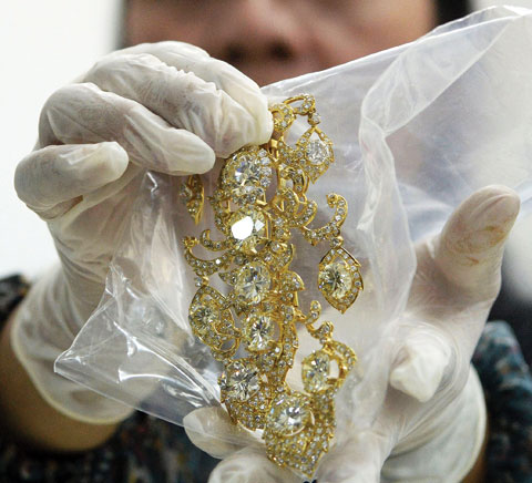 This file photo shows an official from the Presidential Commission on Good Government (PCGG) holding a diamondstudded piece of jewelry seized by the Philippine government from former first lady Imelda Marcos, at the Central Bank headquarters in Manila. — AFP