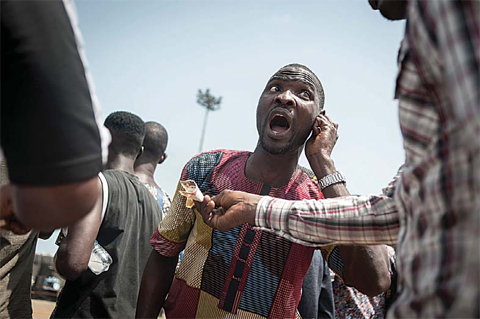 LAGOS: Two men negotiate the price of a bet at a ram fighting competition held at the National Stadium. —AFP