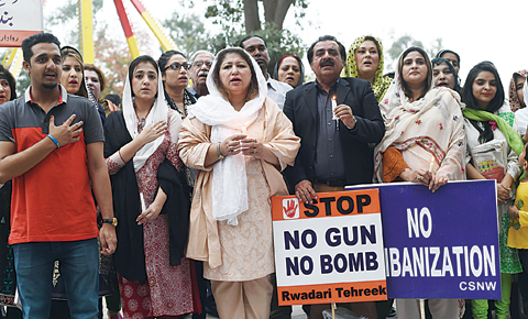 LAHORE: Pakistani civil society members sing the national anthem at the site of a suicide blast yesterday. —AFP