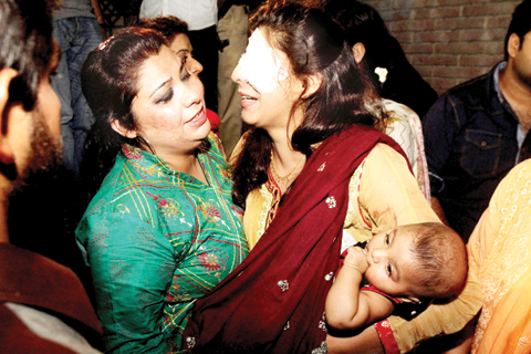 LAHORE: A woman injured in the bomb blast is comforted by a family member at a local hospital in Lahore yesterday. — AP