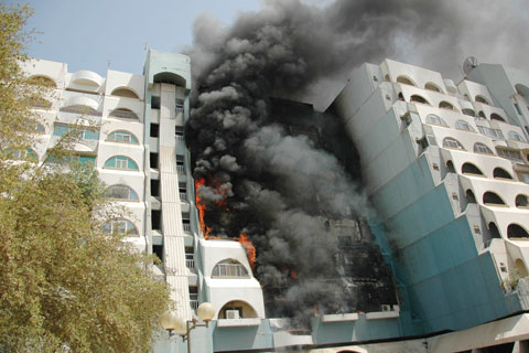 KUWAIT: This file photo shows flames and smoke emitting from a building at the Sawaber Residential Complex in Kuwait City on June 15, 2010. Lingering problems surrounding the 35-year-old complex led the government to evacuate it and proceed with a plan to demolish it. —KUNA
