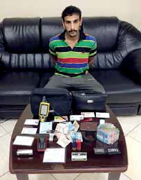 The suspect pictured with stolen items found in his house.