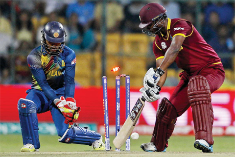 BANGALORE: West Indies’ Johnson Charles, right, is bowled out by Sri Lanka’s Jeffrey Vandersay during their ICC World Twenty20 2016 cricket match in Bangalore, India, yesterday. — AP
