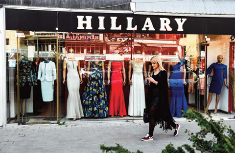 A woman walks past the clothing store ‘Hillary’ in Pristina.— AFP photos