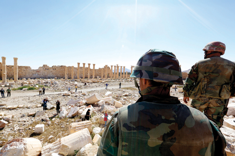 PALMYRA: Soldiers look over damage at the historical Bel Temple in the ancient city. — AP