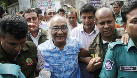 DHAKA: Bangladeshi security personnel escort Shafik Rehman (center) at a court following his arrest in Dhaka yesterday. — AFP