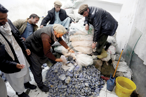 KABUL: Afghan businessmen check lapis lazuli in the city of Kabul, Afghanistan. The brilliant blue stone lapis lazuli, prized for millennia, is almost uniquely found in Afghanistan. — AP