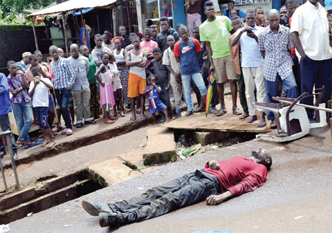CONAKRY: File photo shows a man suspected of being infected with ebola lying dead in the street in Conakry. — AFP