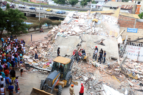 MANTA, ECUADOR: Rescue workers search a collapsed building on Sunday. — AP