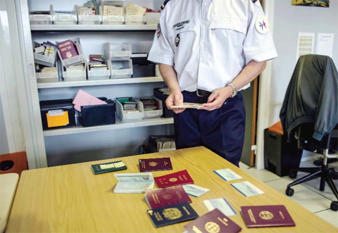 PARIS: French expert of the French Office of False Documents and Identity Fraud, Laurent Gauthier, shows false passports during an interview with The Associated Press. — AP