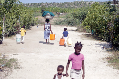 Photo shows residents walking to a banana farm’s irrigation channel to collect water near Leveque - a community where a group of deaf people relocated after the 2010 earthquake in Cabaret, Haiti. — AP