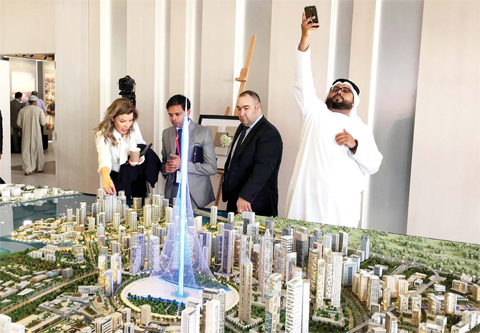 DUBAI: Visitors look at a to-scale model of a new tower the real estate giant Dubai Emaar Properties plans to build that will break the record and be taller than the Burj Khalifa, currently the world’s tallest tower, during an exposition in Dubai yesterday. (Inset) Spanish-Swiss architect Santiago Calatrava Valls (right) and with Emaar Properties Chairman Mohamed Alabbar (left) speak during a press conference in Dubai yesterday.— AFP / AP