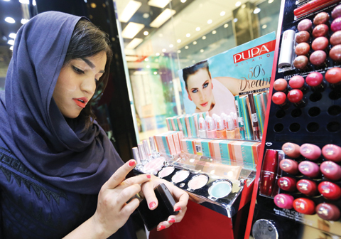 An Iranian woman checks make up at a cosmetics shop in northern Tehran in this file photo. — AFP