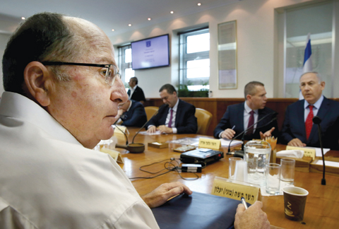 JERUSALEM: Israeli Defense Minister Moshe Yaalon (left) listens during the weekly cabinet meeting in Jerusalem. — AP