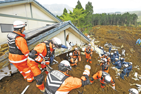 MINAMIASO: Rescuers search for missing persons at the site of a landslide yesterday. — AP