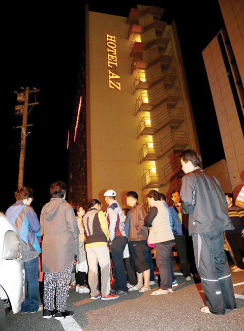 KUMAMOTO: People gather outside a hotel after an earthquake in Kumamoto, southern Japan yesterday. A powerful earthquake with a preliminary magnitude of 6.4 has struck southern Japan. — AP