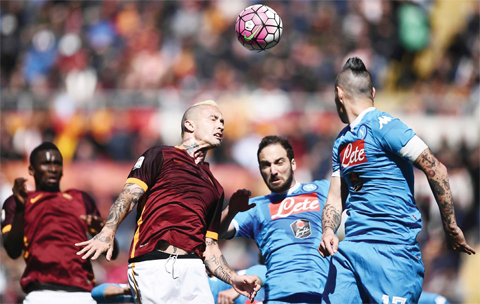 ROME: Roma’s midfielder from Belgium Radja Nainggolan (2ndL) fights for the ball with Napoli’s forward from Argentina Gonzalo Higuain and Napoli’s midfielder from Slovakia Marek Hamsik (R) during the Italian Serie A football match AS Roma vs Napoli yesterday at the Olympic Stadium in Rome. — AFP
