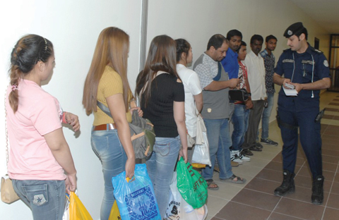 People lined up inside a police station to have their IDs checked