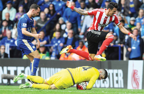 LEICESTER: Southampton’s Jose Fonte, right, jumps over Southampton’s goalkeeper Fraser Forster chased by Leicester’s Daniel Drinkwater during the English Premier League soccer match between Leicester City and Southampton at the King Power Stadium in Leicester, England, yesterday. — AP